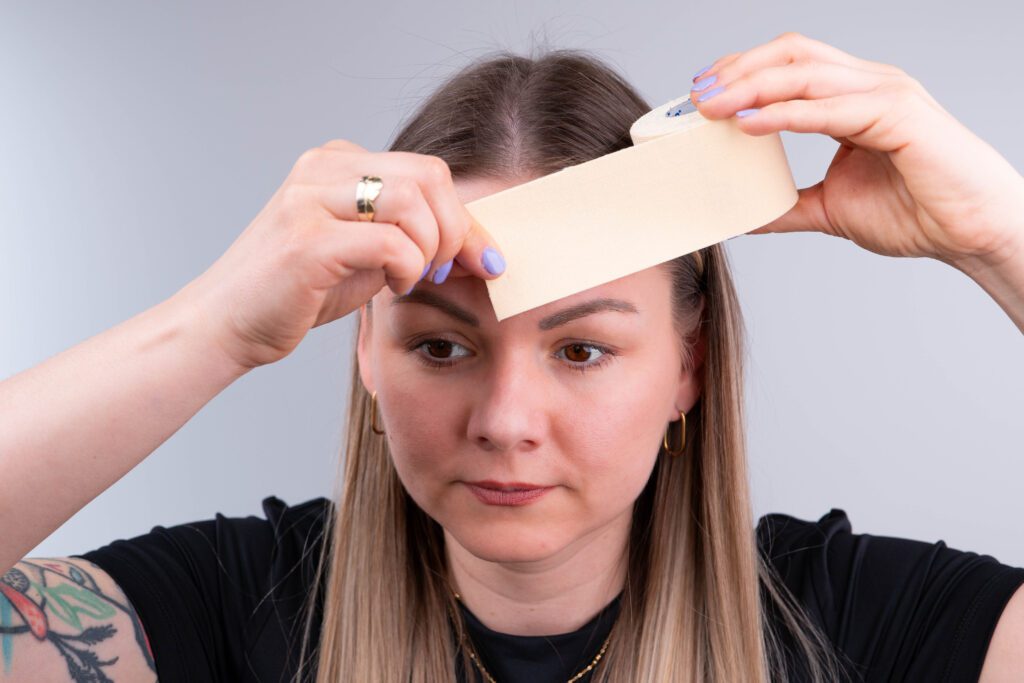 Woman (Zoja Kapustova) showing beauty tape
